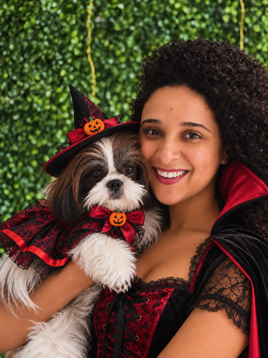Deisiane França, fundadora da PomPom Pet, com um cachorro em trajes de Halloween